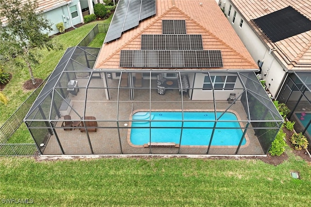 view of swimming pool featuring a lanai, a lawn, and a patio area