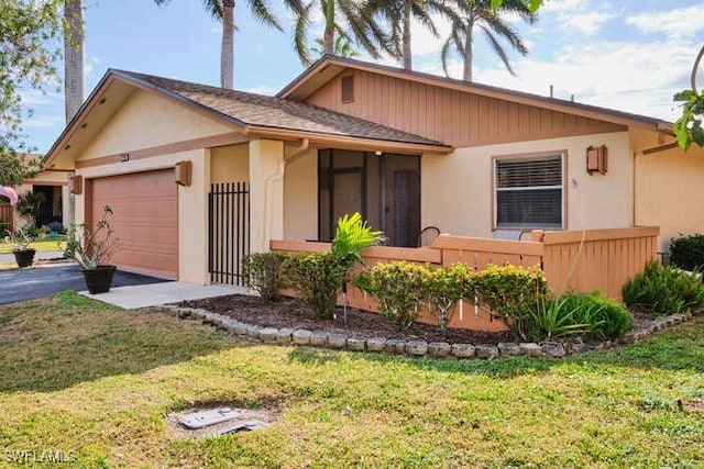 ranch-style home featuring a garage and a front lawn