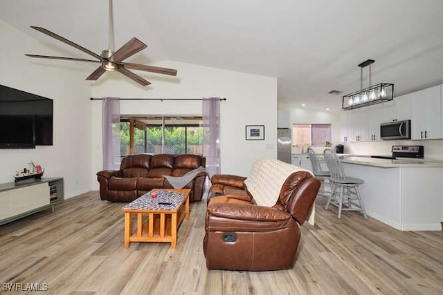 living room featuring ceiling fan, light hardwood / wood-style flooring, and lofted ceiling