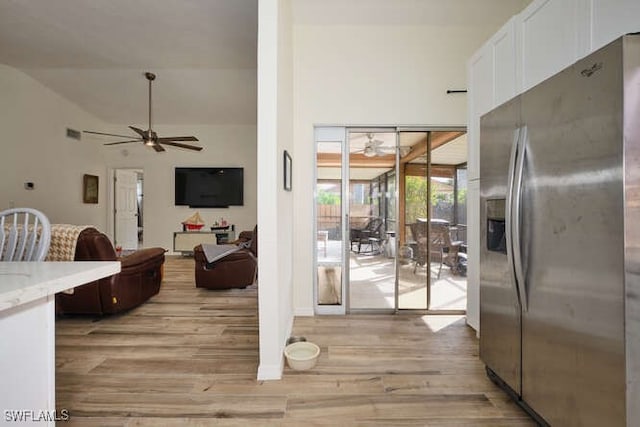 kitchen featuring ceiling fan, light hardwood / wood-style floors, white cabinets, and stainless steel fridge