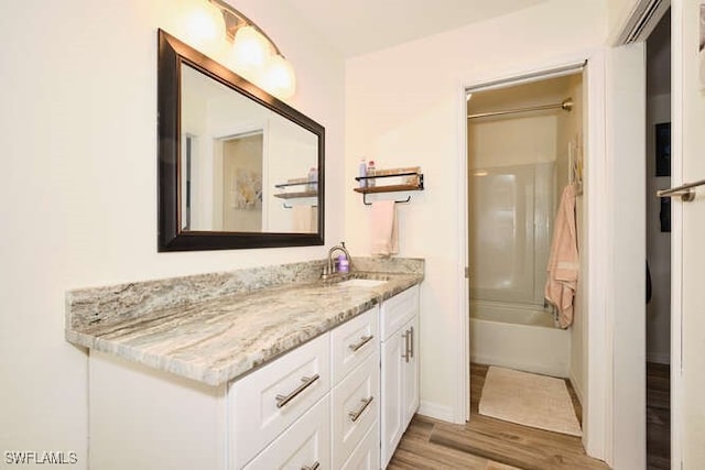 bathroom featuring vanity, shower / washtub combination, and hardwood / wood-style flooring