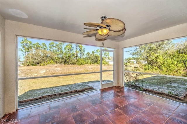 unfurnished sunroom with ceiling fan