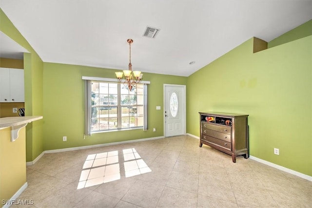 interior space featuring a notable chandelier, light tile patterned floors, and vaulted ceiling