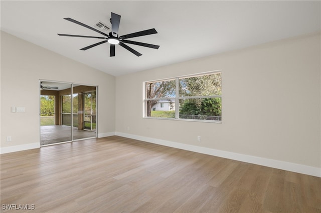 empty room with vaulted ceiling and light hardwood / wood-style floors