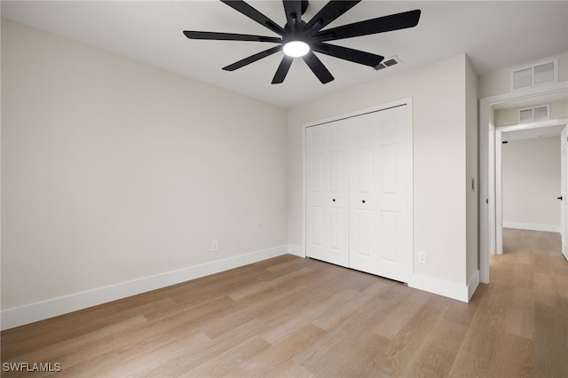 unfurnished bedroom with ceiling fan, a closet, and light wood-type flooring