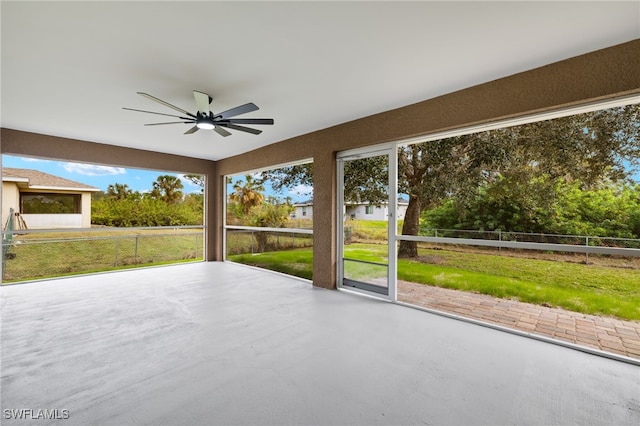 unfurnished sunroom featuring ceiling fan