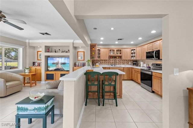 kitchen featuring a kitchen bar, ceiling fan, stainless steel electric stove, sink, and light tile patterned flooring