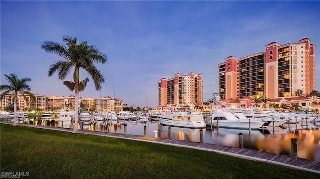 surrounding community with a yard, a dock, and a water view