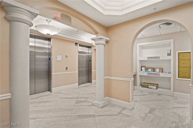 hallway featuring built in shelves, ornamental molding, elevator, and decorative columns