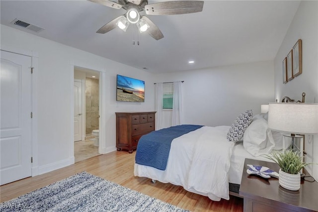 bedroom with ceiling fan, connected bathroom, and light hardwood / wood-style flooring