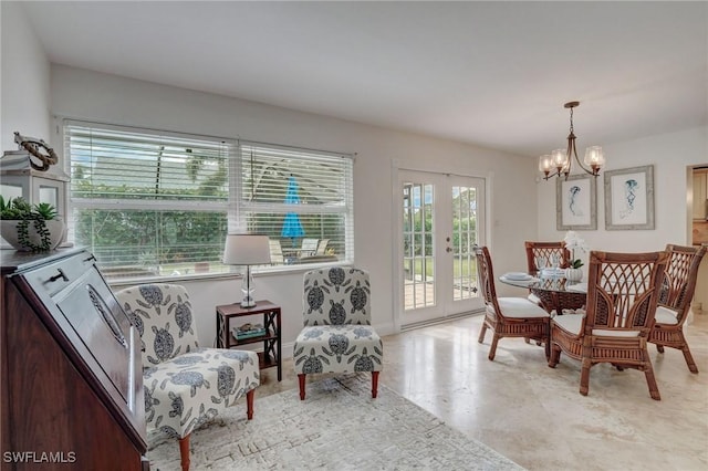 sitting room with french doors and a notable chandelier