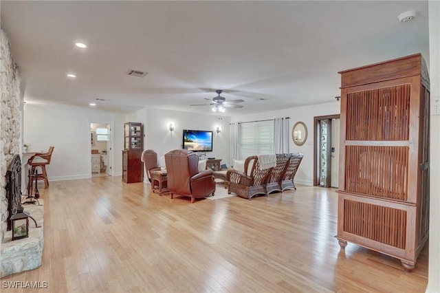 living room featuring ceiling fan and light hardwood / wood-style flooring