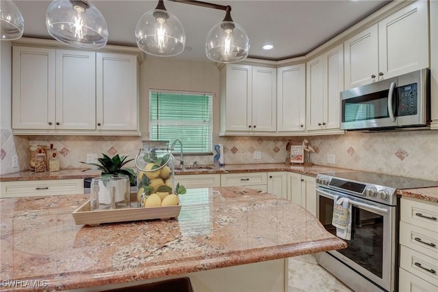 kitchen with decorative backsplash, light stone counters, hanging light fixtures, and stainless steel appliances