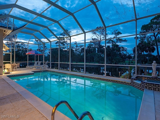 view of swimming pool featuring a jacuzzi, a patio area, and a lanai