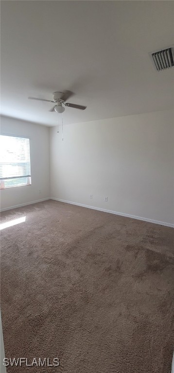 spare room featuring carpet flooring and ceiling fan