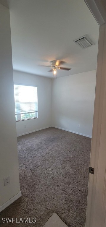 spare room with dark carpet and ceiling fan