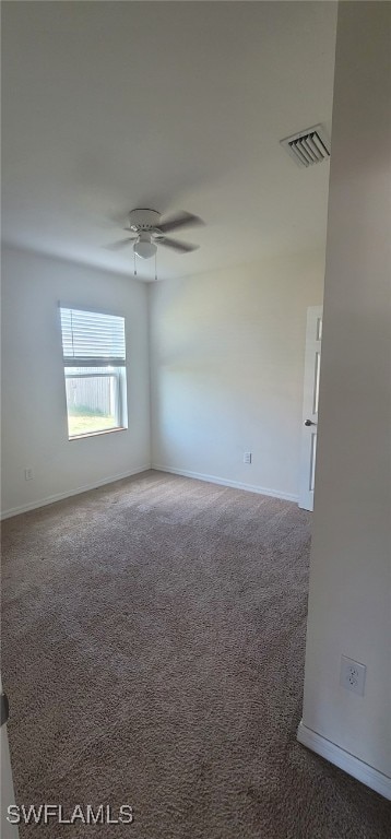 empty room with dark carpet and ceiling fan