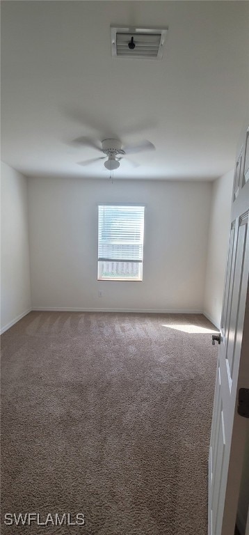 spare room with ceiling fan and carpet