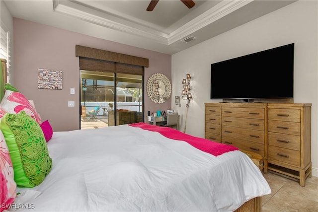 bedroom with ceiling fan, a tray ceiling, and access to exterior