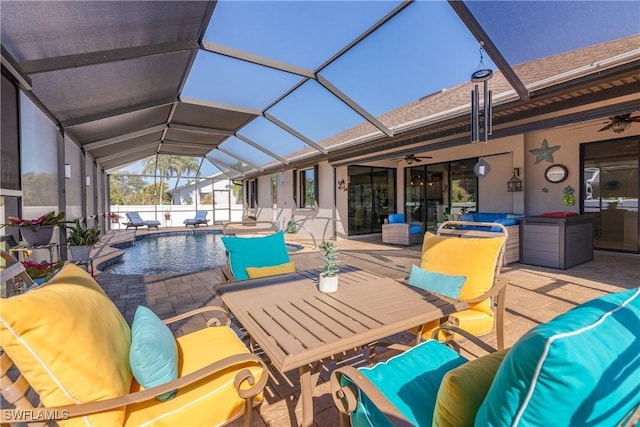 view of patio featuring ceiling fan and glass enclosure