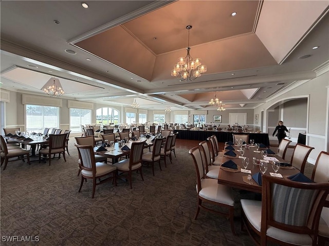 carpeted dining space featuring a raised ceiling, a notable chandelier, and crown molding