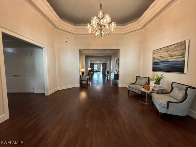 corridor featuring baseboards, ornamental molding, dark wood-style floors, and a notable chandelier
