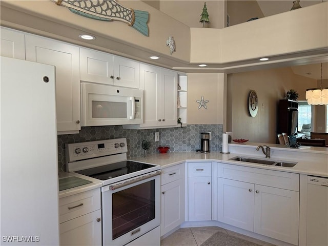 kitchen with white appliances, white cabinetry, sink, and light tile patterned floors