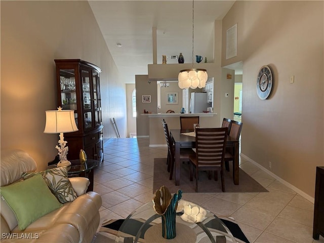 tiled dining space featuring a high ceiling