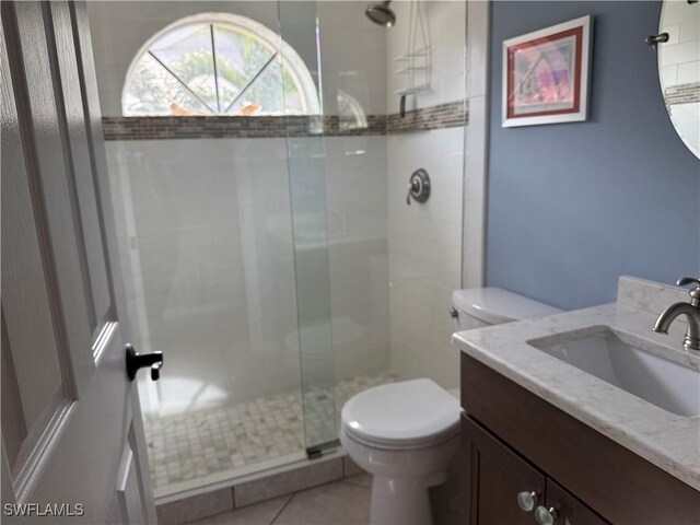 bathroom featuring vanity, tile patterned floors, toilet, and a shower stall