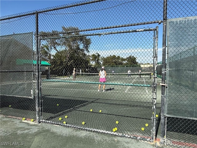view of tennis court featuring fence