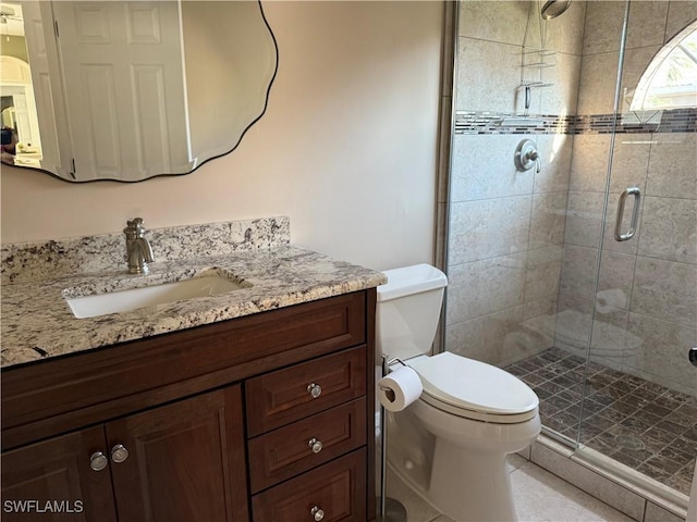 bathroom with toilet, a shower with door, and vanity