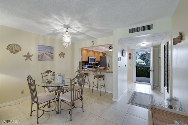 dining space with ceiling fan and light tile patterned floors