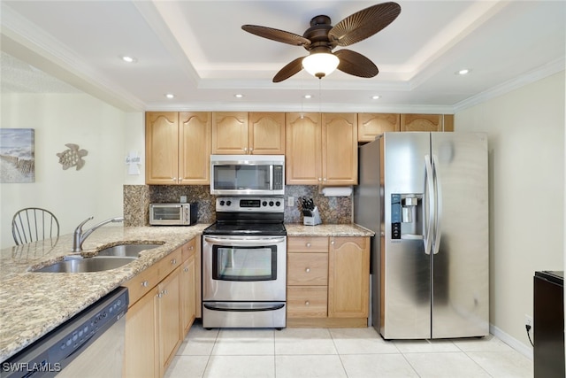 kitchen featuring sink, a tray ceiling, stainless steel appliances, and light tile patterned flooring