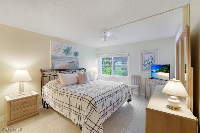 bedroom with ceiling fan, a textured ceiling, and light tile patterned floors