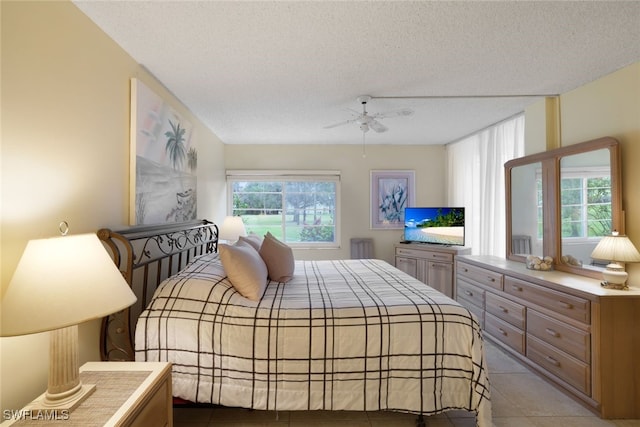 tiled bedroom with a textured ceiling and ceiling fan