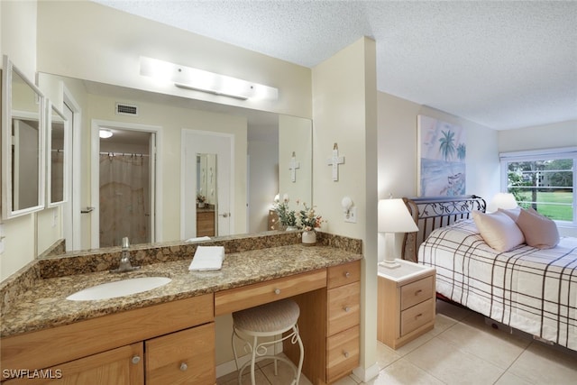 bathroom featuring vanity, tile patterned flooring, and a textured ceiling