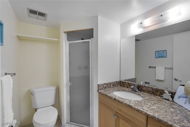 bathroom with toilet, a shower with shower door, and vanity