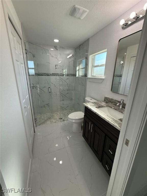 bathroom with vanity, toilet, and a shower with door