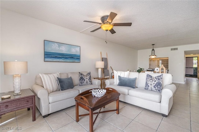 tiled living room featuring a textured ceiling and ceiling fan