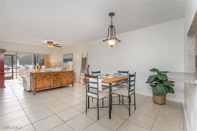 tiled dining area with ceiling fan and a textured ceiling