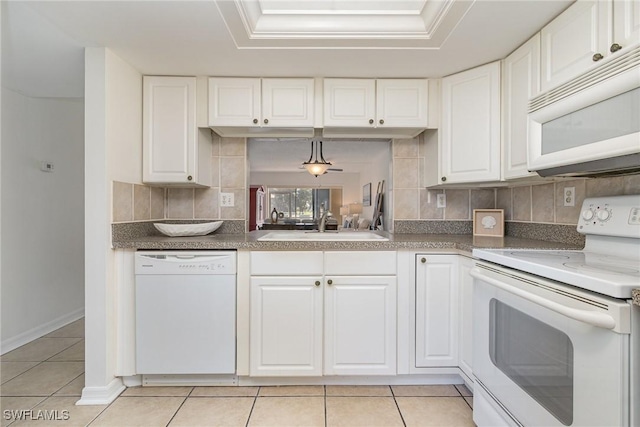 kitchen with white appliances, white cabinets, sink, light tile patterned floors, and decorative light fixtures