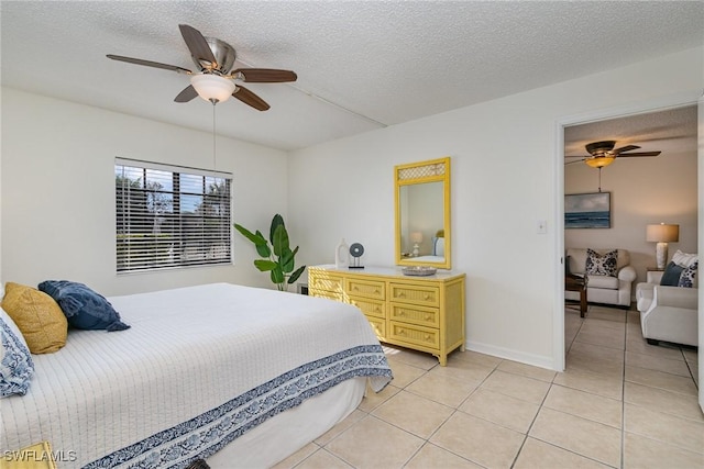 tiled bedroom with ceiling fan and a textured ceiling