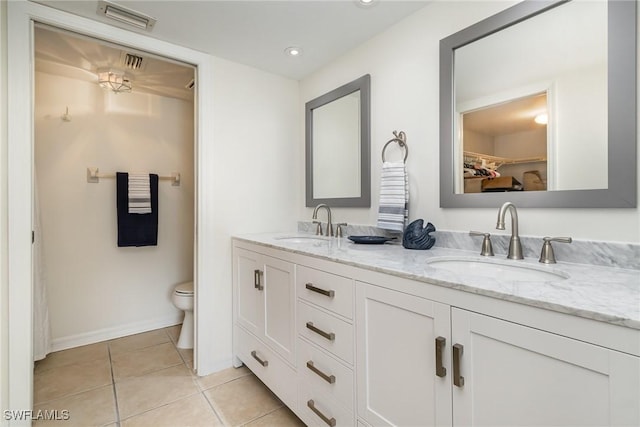 bathroom with tile patterned flooring, vanity, and toilet