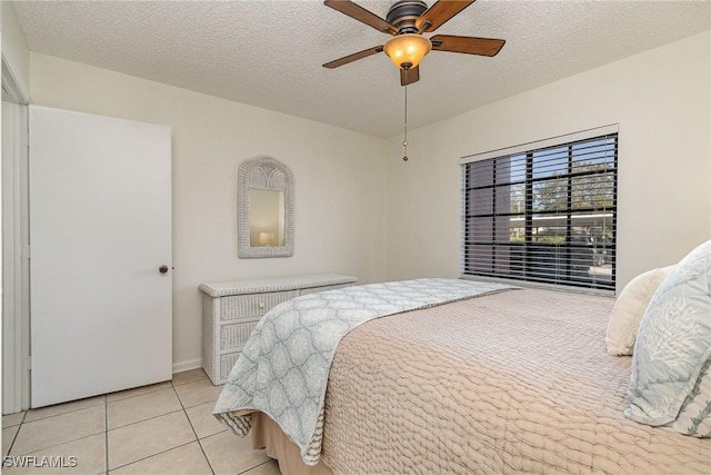 bedroom with light tile patterned floors, a textured ceiling, and ceiling fan