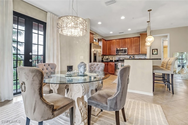 tiled dining area with a chandelier and french doors