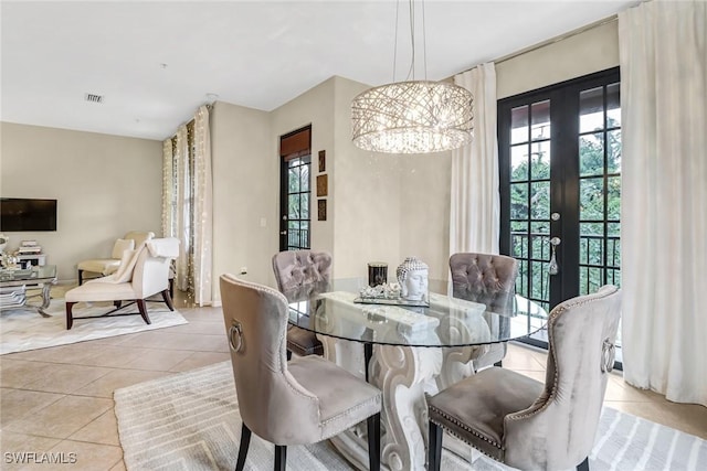 tiled dining room with a chandelier and french doors