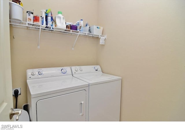 clothes washing area with washer and clothes dryer