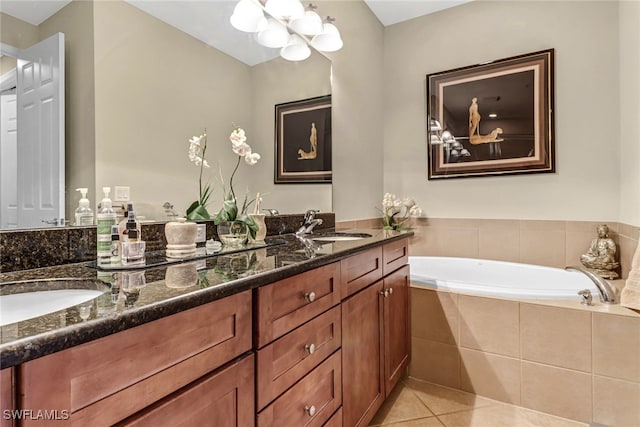 bathroom with vanity, tiled tub, a notable chandelier, and tile patterned flooring