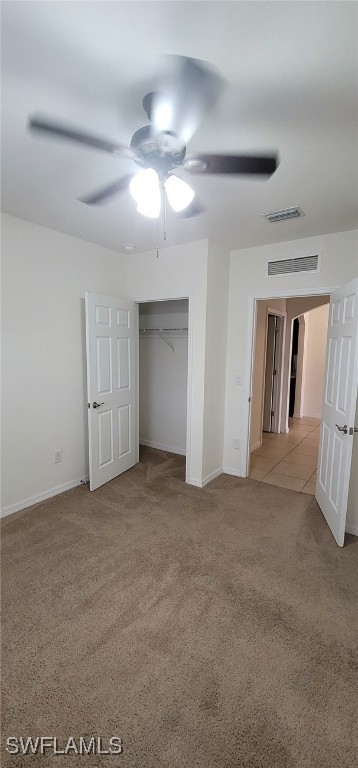 unfurnished bedroom featuring ceiling fan, light colored carpet, and a closet