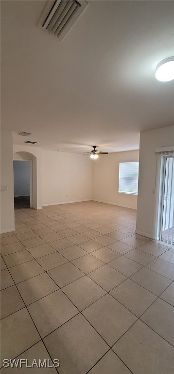 spare room with ceiling fan and light tile patterned flooring